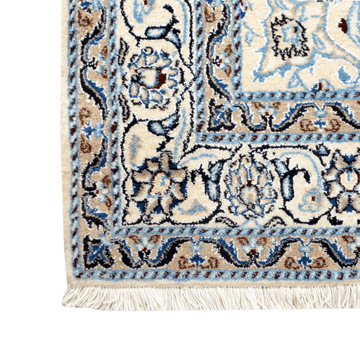 Cam Rugs: A corner of a cream base handmade Nain wool area rug, with accented blue details of floral motif designs. 