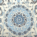 Cam Rugs: The center medallion of a  cream base handmade Nain wool area rug, with accented blue details of floral motif designs. 