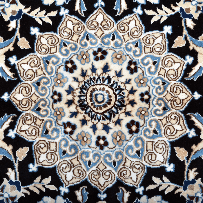 Cam Rugs: The center medallion of a cream base handmade Nain wool area rug, with accented black details of floral motif designs. 