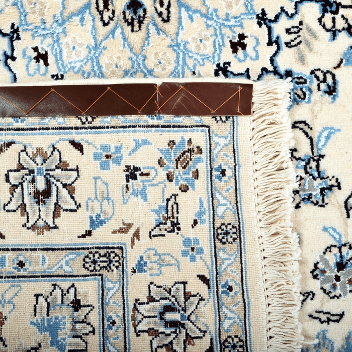 Cam Rugs: The back of a cream base handmade Nain wool area rug, with details of floral motif designs.