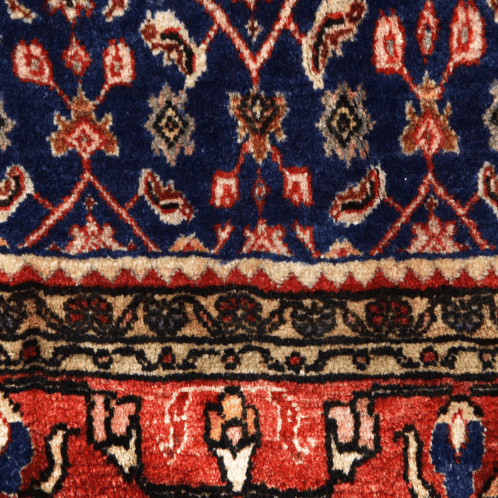 Cam Rugs: A close-up detail of a red handmade Kashkoli wool area rug, with a traditional geometric motif design. 