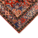 Cam Rugs: A close-up corner of a red handmade Kashkoli wool area rug, with a traditional geometric motif design. 