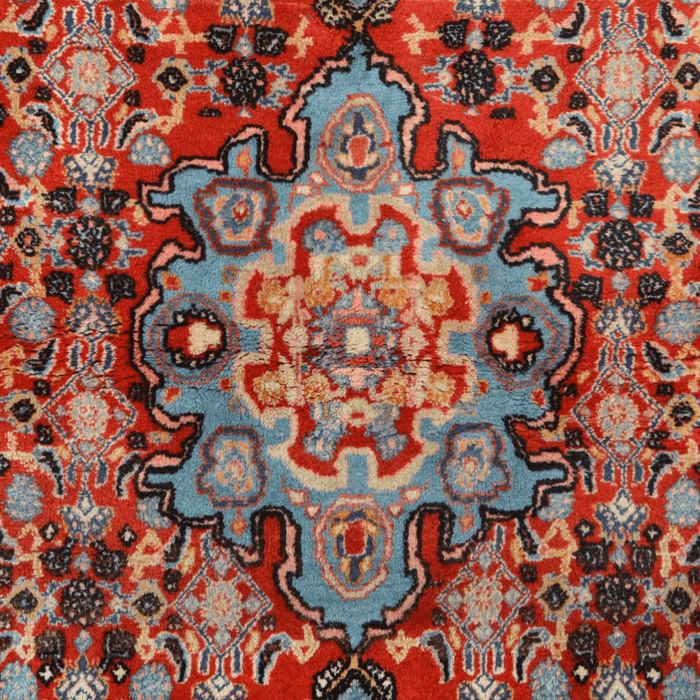 Cam Rugs: The center of a red handmade Kashkoli wool area rug, with a traditional geometric motif design. 