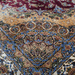 A detail of an Authentic Red Modal Silk area rug with traditional floral motif designs.