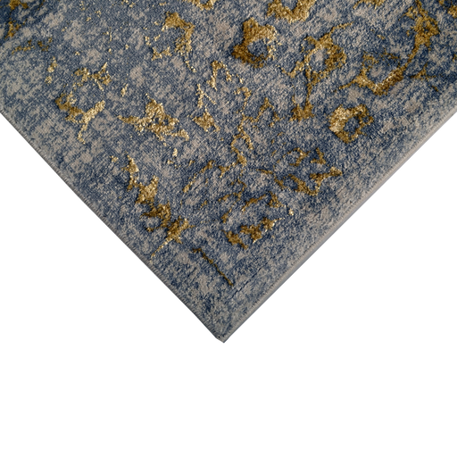 A corner of a beige area rug with distressed traditional floral motifs.