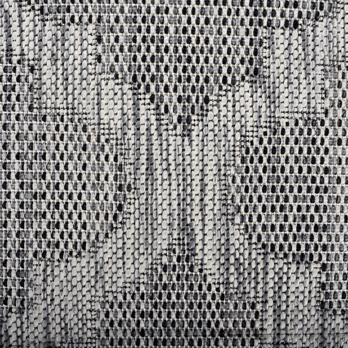A detail of a grey flat weave outdoor rug with modern geometric designs.