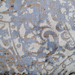 A detail of a blue area rug with distressed traditional floral motif designs.