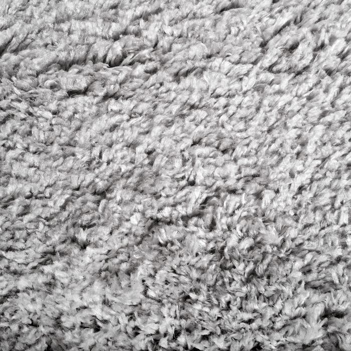 A detail of a solid grey shag area rug.