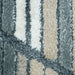 A close-up corner blue, beige and cream area rug with triangle and striped geometric designs.