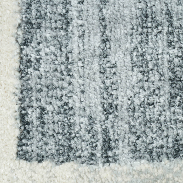 A close-up detail of a blue and cream area rug with geometric designs.