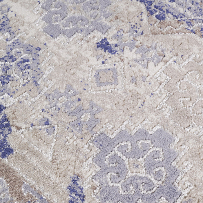 A detail of a pink and purple textured area rug with distressed traditional geometric floral motif designs.