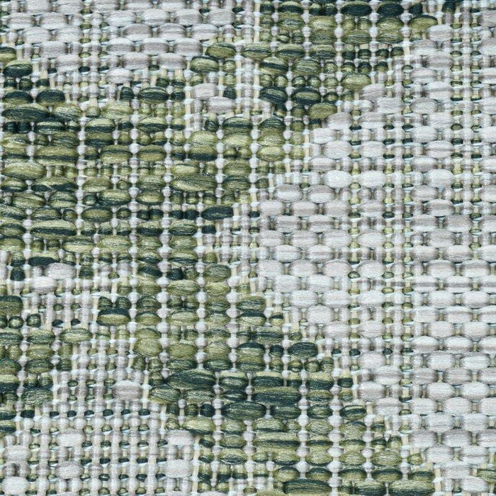 A detail of a green flat weave outdoor rug with geometric diamond designs.