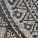 A detail of a black and grey flat weave outdoor rug with floral motif designs.