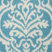 A detail of a green area rug, with floral damask designs.