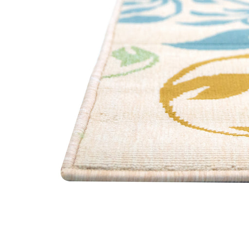 A corner of a cream area rug with blue, green, and yellow floral designs.