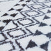 A close-up detail of a black and white area rug with geometric designs.