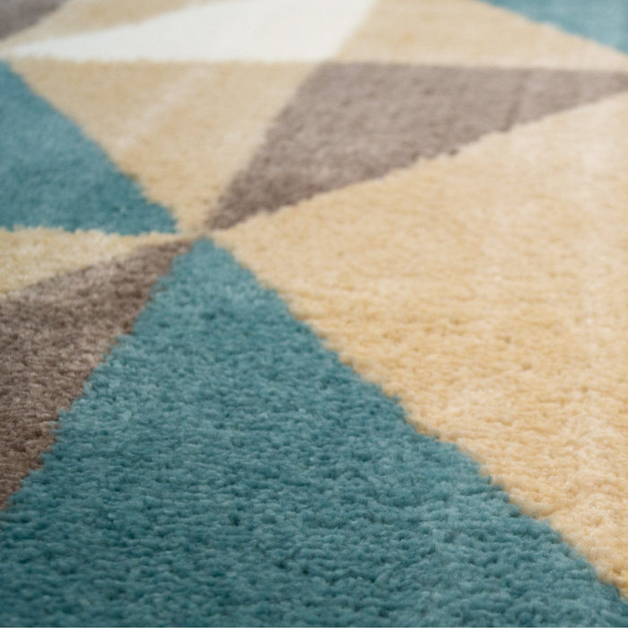 A close-up detail of a multi-coloured area rug with geometric triangle designs.