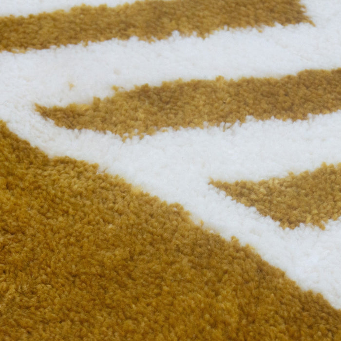A close-up detail of a yellow and white area rug with geometric designs.