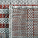 The back of a red flat weave outdoor runner rug with striped designs.