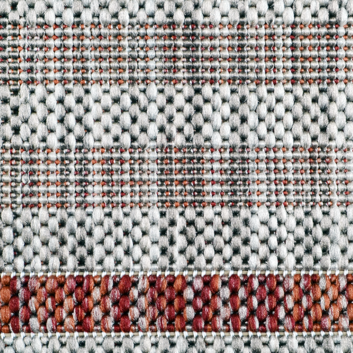 A detail of a red flat weave outdoor runner rug with striped designs.