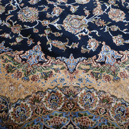 A detail of an Authentic Navy Modal Silk area rug with traditional floral motif designs.