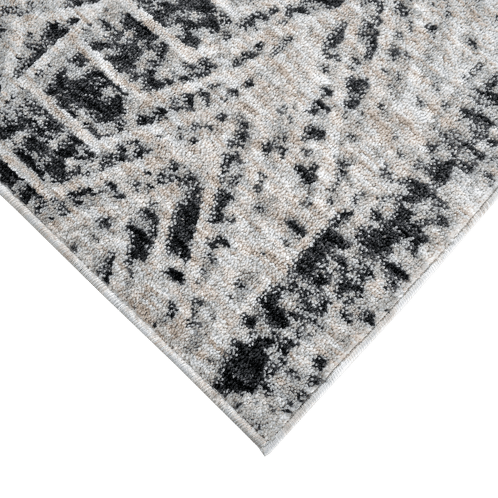 Corner of a CamRugs.Ca grey geometric area rug, made from recycled materials.