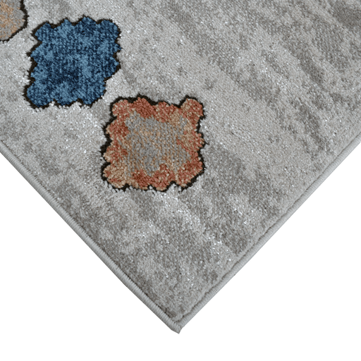 Corner of a CamRugs beige geometric area rug.