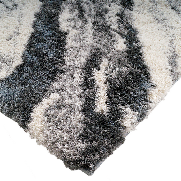 A corner of a grey textured area rug with a marbled design.