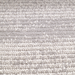 A detail of a grey textured area rug with embossed striped designs.